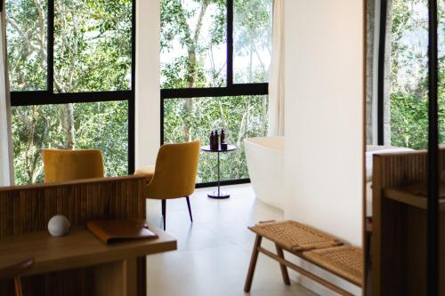 a room with large windows and a tub and chairs at Naatooh Guest Houses in Florianópolis