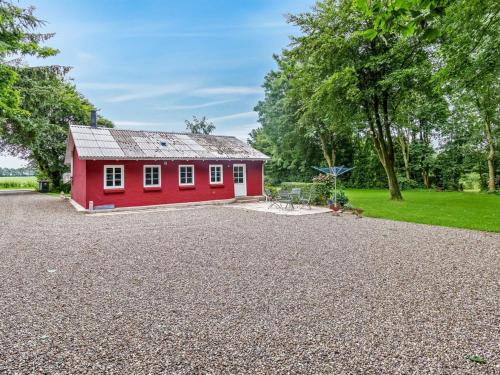 a red house with a gravel driveway at Holiday Home Saran - 30km from the sea by Interhome in Toftlund