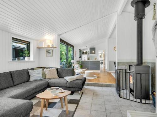 a living room with a couch and a fireplace at Holiday Home Aleida - 400m from the sea by Interhome in Jerup