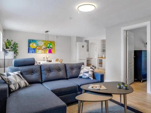 a living room with a blue couch and a table at Holiday Home Saran - 30km from the sea by Interhome in Toftlund