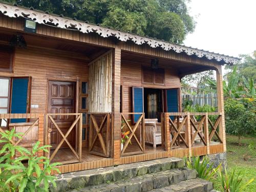 a wooden house with open doors and a porch at Roça Saudade Guest House in Trindade