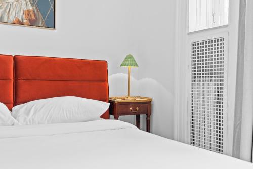 a bedroom with a bed and a table with a lamp at Le Chateau de Pierre in Quebec City