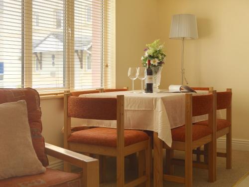 a dining room table with chairs and a vase of flowers at Tralee Town Centre Apartments in Tralee
