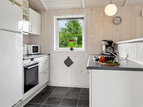 a kitchen with white appliances and a window at Holiday Home Tayana - 700m from the sea by Interhome in Neder Lysabild