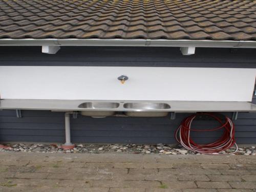 two pots and pans on a shelf under a roof at Holiday Home Edzard - 800m from the sea by Interhome in Neder Lysabild