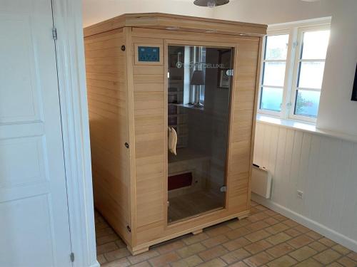 VejbyにあるHoliday Home Susan - 20m from the sea by Interhomeの木製のキャビネット(ガラスドア付)