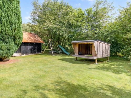 a playground with a house and a swing at Holiday Home Engelbertine - 30km from the sea by Interhome in Toftlund
