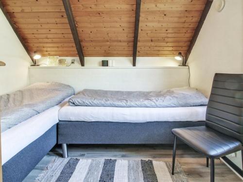 a room with two beds and a chair in it at Holiday Home Engelbertine - 30km from the sea by Interhome in Toftlund