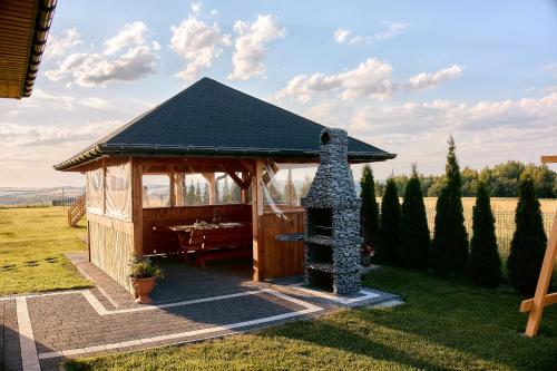 a gazebo with a stove in a field at Dom Ci Spokój in Czudec