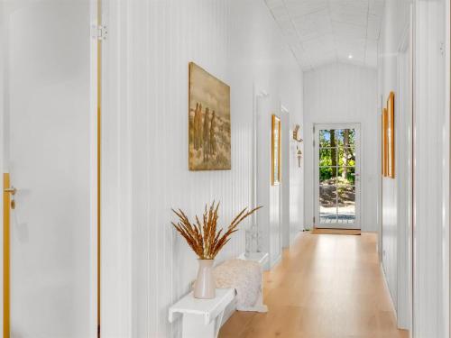 a hallway with white walls and a vase with a plant at Holiday Home Gedda - from the sea by Interhome in Hals