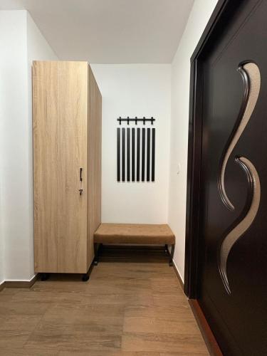 a hallway with a wooden bench and a door at Comodo Studio in Turda