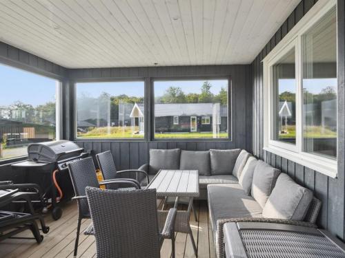 a screened in porch with a couch and a grill at Holiday Home Alka - 500m from the sea by Interhome in Sjølund
