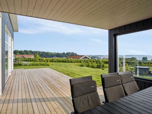 two chairs sitting on a wooden deck with a view at Holiday Home Alka - 500m from the sea by Interhome in Sjølund