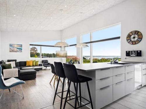a kitchen and living room with a counter and stools at Holiday Home Alka - 500m from the sea by Interhome in Sjølund