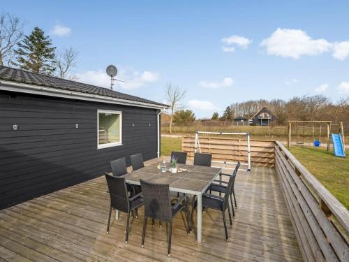 a wooden deck with a table and chairs on it at Holiday Home Amine - 300m to the fjord by Interhome in Skjern