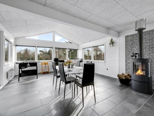 a dining room with a table and chairs and a fireplace at Holiday Home Amine - 300m to the fjord by Interhome in Skjern