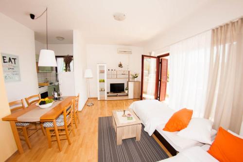 a living room with a white bed and a table at Apartments Labinac in Pula