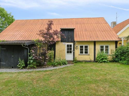 a yellow house with an orange roof and a yard at Apartment Ejna - 400m from the sea by Interhome in Neksø