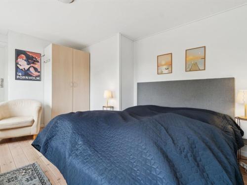 a bedroom with a blue bed and a chair at Apartment Ejna - 400m from the sea by Interhome in Neksø