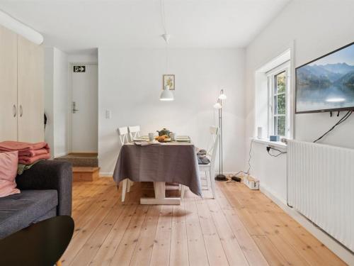 a white living room with a table and a couch at Apartment Ejna - 400m from the sea by Interhome in Neksø