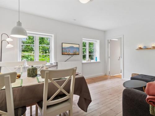 a dining room and living room with a table and chairs at Apartment Ejna - 400m from the sea by Interhome in Neksø