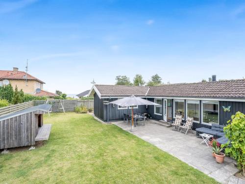 a house with a patio and a yard at Holiday Home Tenho - 150m from the sea by Interhome in Strøby