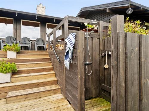 a wooden fence with a wooden stairs and a patio at Holiday Home Yardila - 1-4km from the sea by Interhome in Tisvildeleje