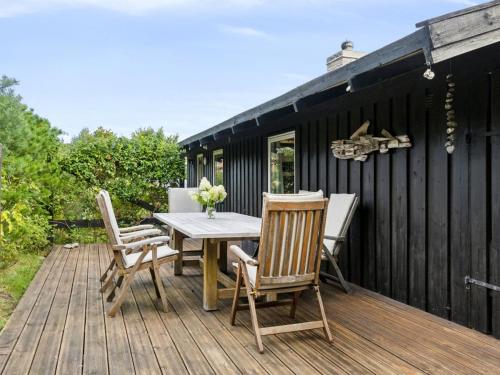 a wooden deck with a table and chairs on it at Holiday Home Yardila - 1-4km from the sea by Interhome in Tisvildeleje