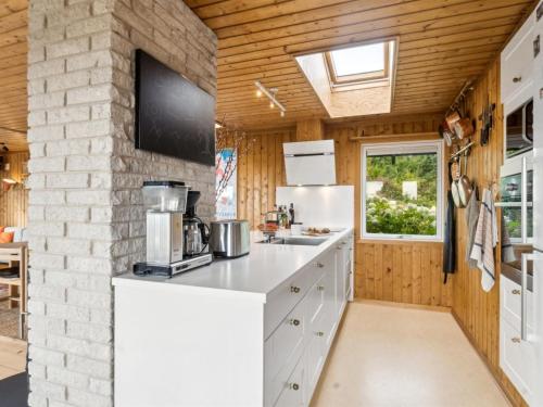 a kitchen with a white counter and a window at Holiday Home Yardila - 1-4km from the sea by Interhome in Tisvildeleje
