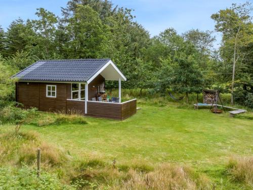a small cabin in the middle of a yard at Holiday Home Unge - 2-9km from the sea by Interhome in Blokhus