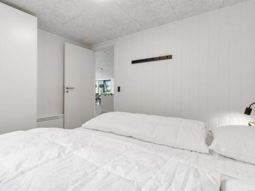 a white bedroom with a large white bed at Holiday Home Wilgrib - 50m from the sea by Interhome in Rønne
