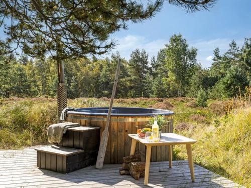 a wooden tub sitting next to a table and a table sidx at Holiday Home Dagny - 520m from the sea by Interhome in Læsø