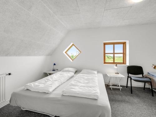a white bedroom with a bed and a desk and a window at Holiday Home Darleen - 850m to the fjord by Interhome in Vemb