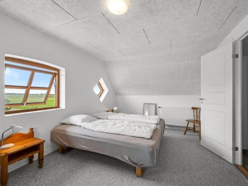 a bedroom with a bed and a table and a window at Holiday Home Darleen - 850m to the fjord by Interhome in Vemb