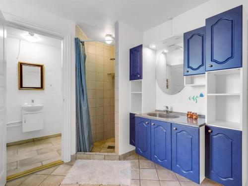 a blue bathroom with a sink and a shower at Holiday Home Darleen - 850m to the fjord by Interhome in Vemb