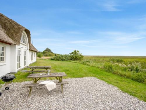 a picnic table and a grill outside of a building at Holiday Home Darleen - 850m to the fjord by Interhome in Vemb