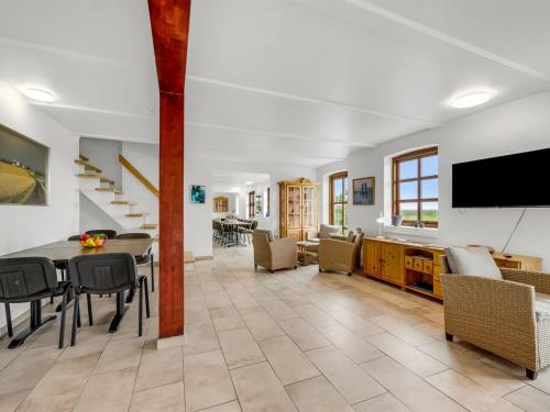 a living room with a table and chairs and a tv at Holiday Home Darleen - 850m to the fjord by Interhome in Vemb