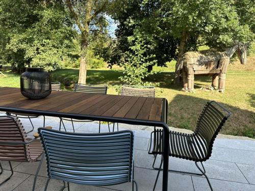 a wooden table and chairs with a table and a park at Ferienhaus Gersmühle in Satteldorf