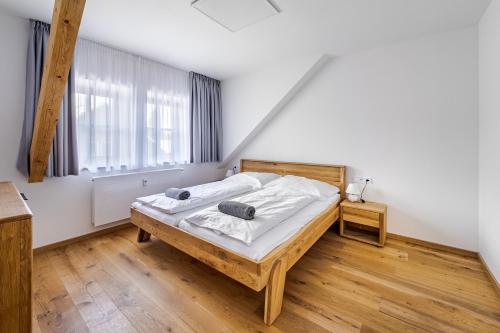 a bedroom with a wooden bed and a large window at Wellness apartmán Pila Kvilda in Kvilda