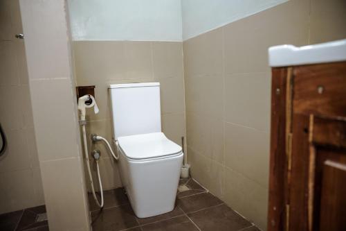a bathroom with a white toilet in a stall at Abbi Holidays - Jaffna Luxurious Villa in Jaffna