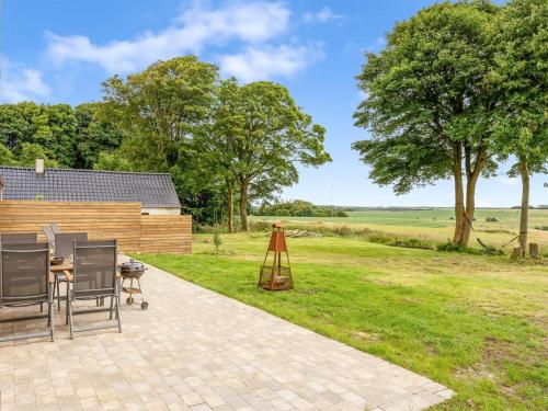 a patio with a table and chairs next to a field at Apartment Geraldine - 3-5km to the fjord by Interhome in Spottrup