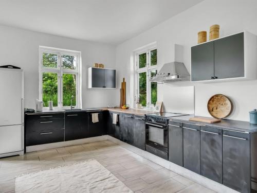a kitchen with black cabinets and white appliances at Apartment Geraldine - 3-5km to the fjord by Interhome in Spottrup