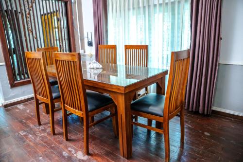 a dining room table and chairs with a glass table and chairs at Abbi Holidays - Jaffna Luxurious Villa in Jaffna