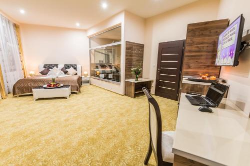 a bedroom with a bed and a desk with a laptop at Miraj Resort in Lučenec