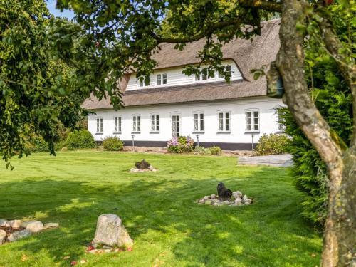 a white house with a green yard with rocks at Holiday Home Vinni - 25km from the sea by Interhome in Rødding