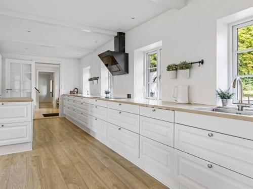 a kitchen with white cabinets and a sink at Holiday Home Vinni - 25km from the sea by Interhome in Rødding