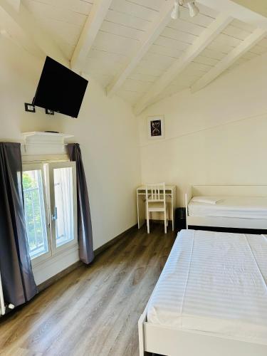 a bedroom with two beds and a flat screen tv at Giardini B&B in Modena
