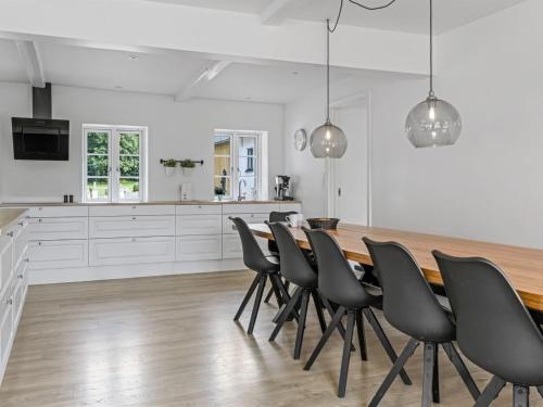 a kitchen with a dining room table and chairs at Holiday Home Vinni - 25km from the sea by Interhome in Rødding