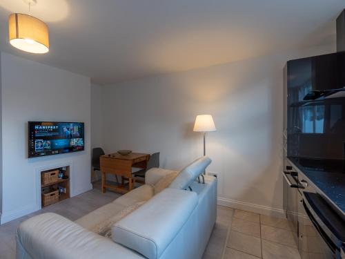 a living room with a couch and a flat screen tv at Luxury ground floor modern flat close to city with free parking in Leeds
