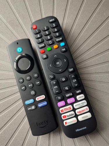 two remote controls sitting on top of a couch at Luxury ground floor modern flat close to city with free parking in Leeds
